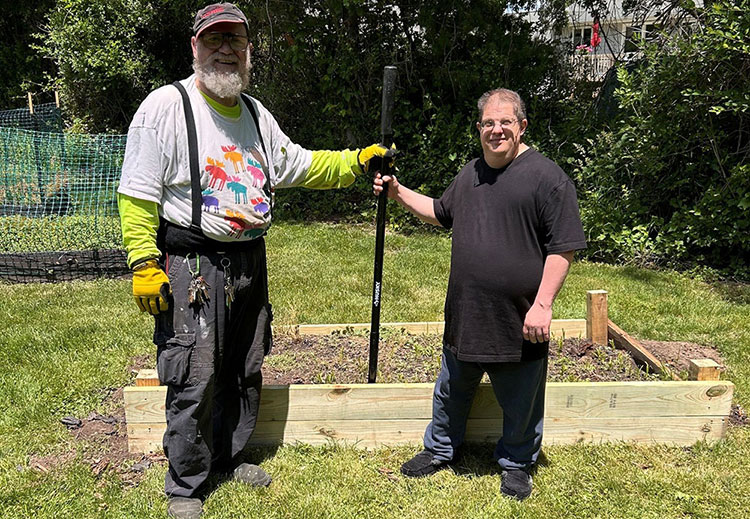 Rose House Maintenance Coordinator Steve Henley poses with resident Billy after building new garden beds for the volunteers.